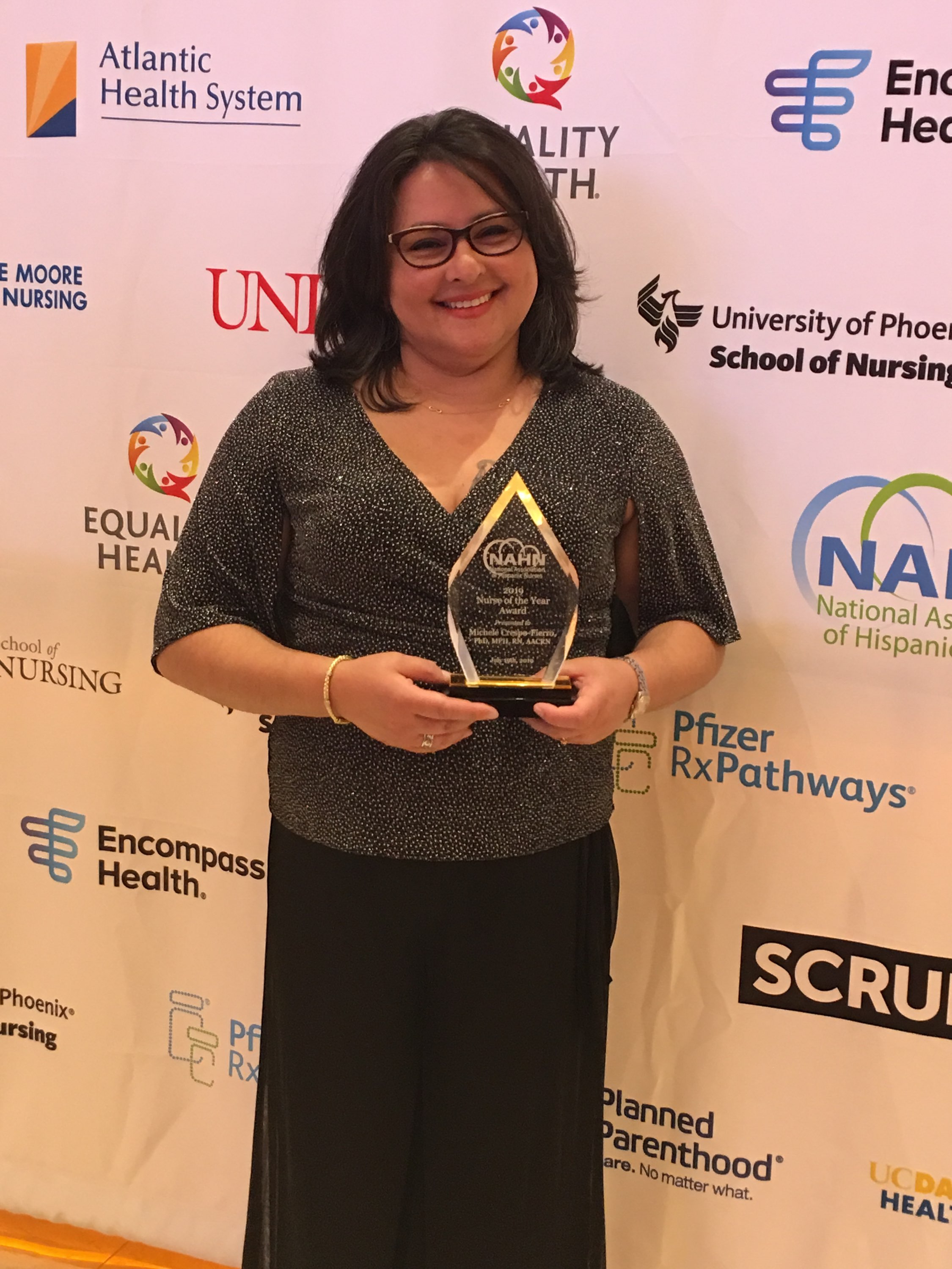 Prof. Michele Crespo-Fierro holding NAHN award