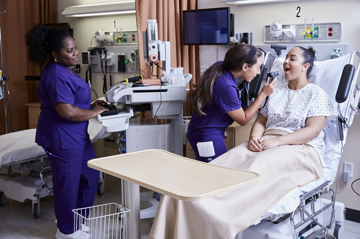 Nursing student in the simulation center examining mock patient