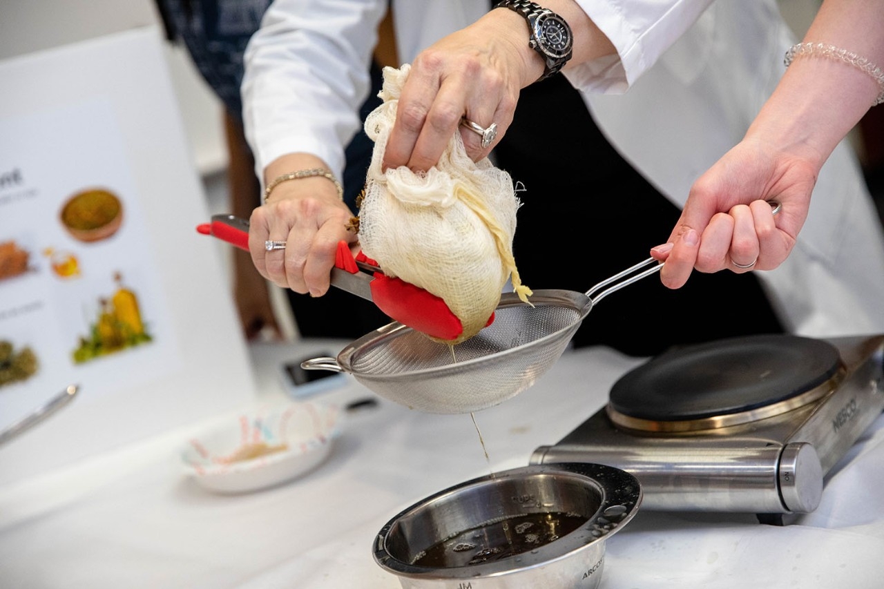 Student straining herbal concoction