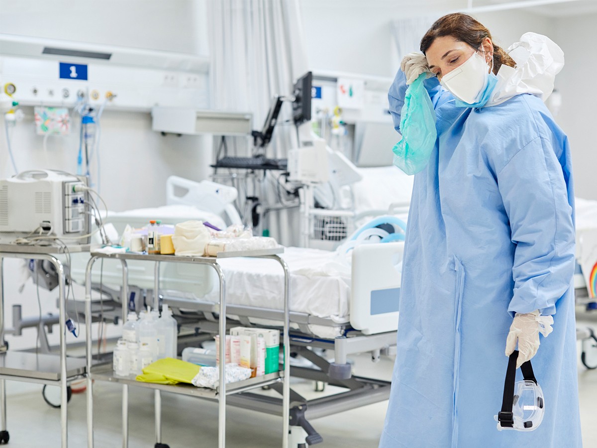 Nurse in lab gown, tired and stressed 