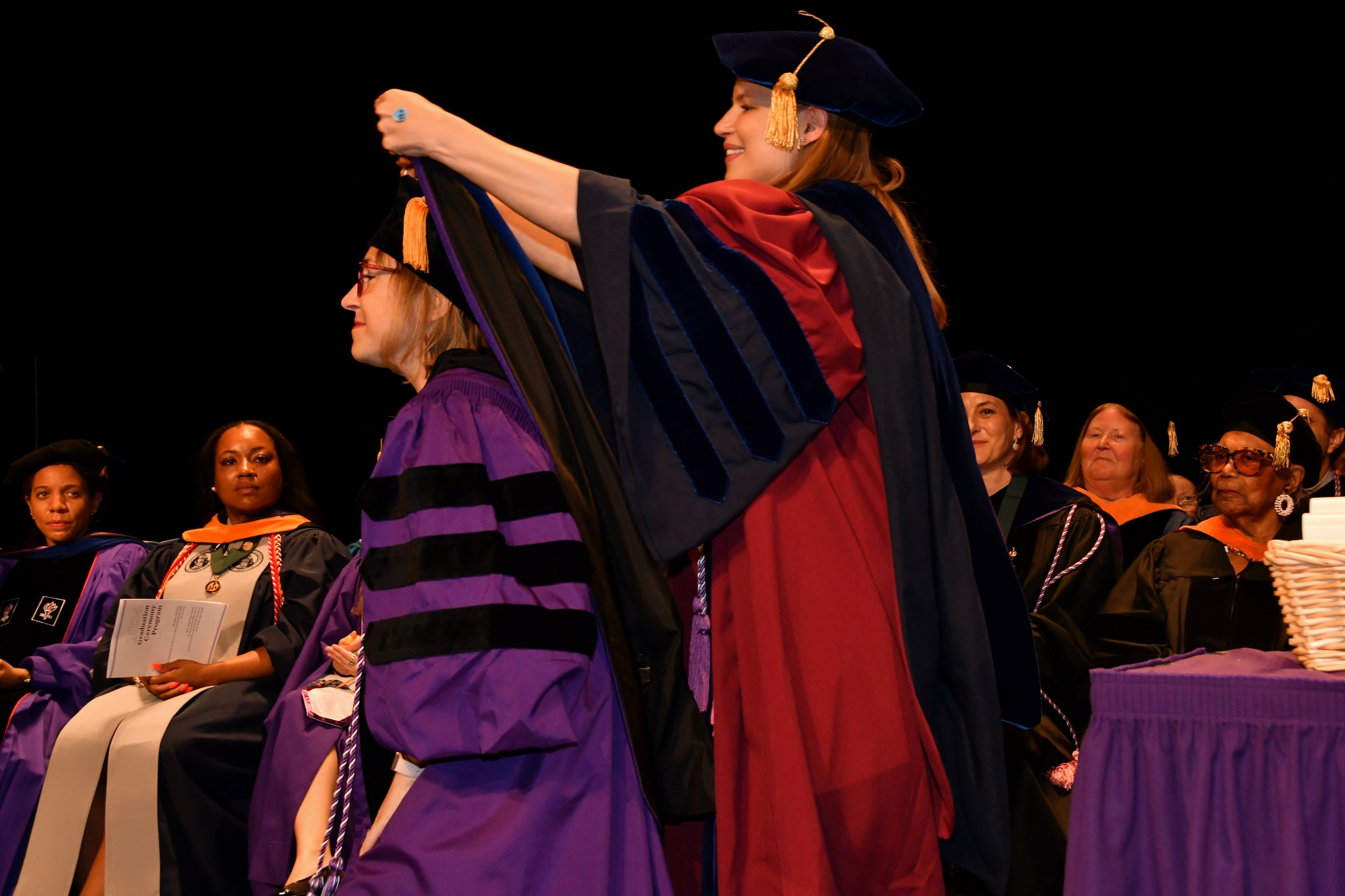 PhD student getting hooded by Amy Witkoski Stimpfel at graduation