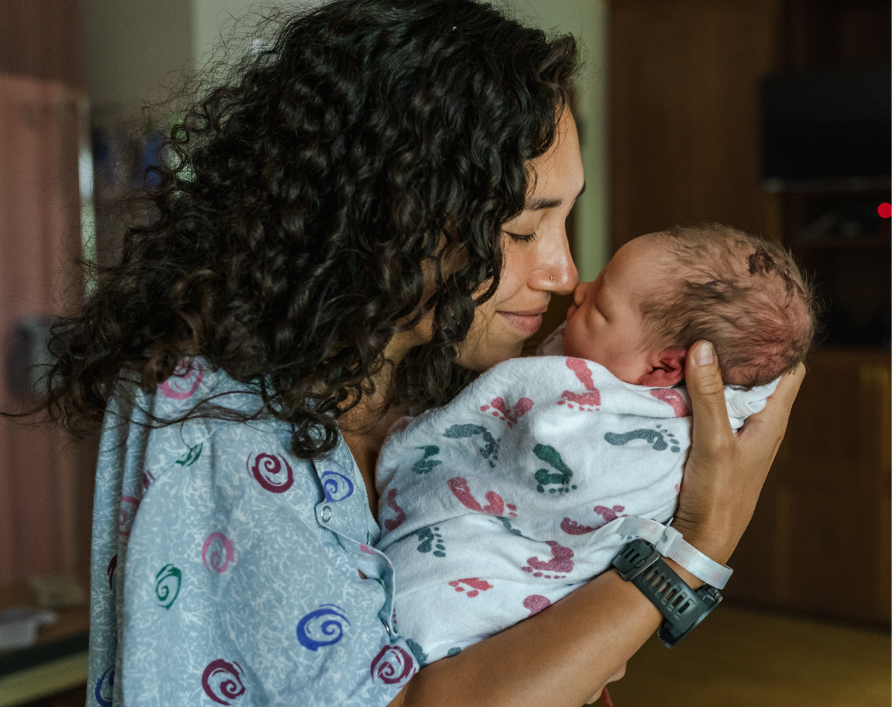 Mom holding her newborn baby in hospital room