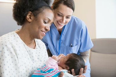 Mother holding baby and nurse