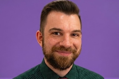 headshot of adam poltrack against an nyu purple background