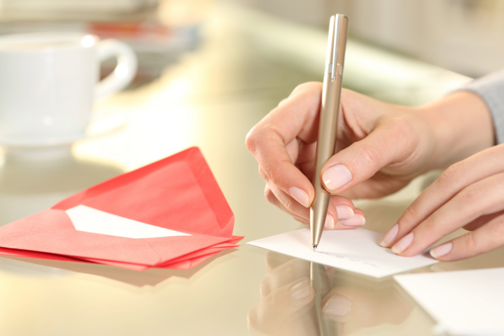 person writing postcard