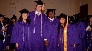Students smile in purple graduation attire