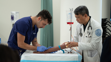 Student and instructor in clinical lab assessing an arm 