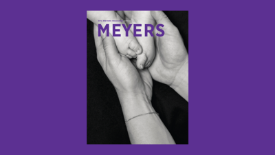 NYU Meyers Magazine cover, black and white adult hands holding baby feet