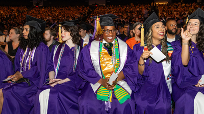 Jasmin LeCadre is sitting and smiling at graduation
